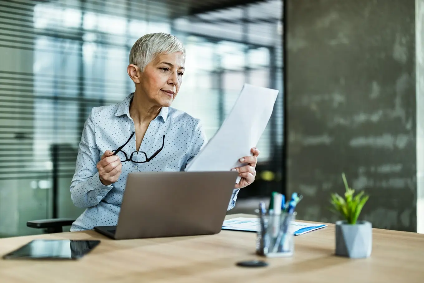 kobieta z dokumentami przed laptopem